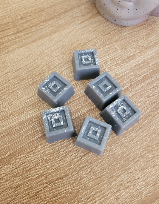 Fondant parfumé artisanal gris en forme de carré, senteur thé noir chaud et épicé pour intérieur cosy.