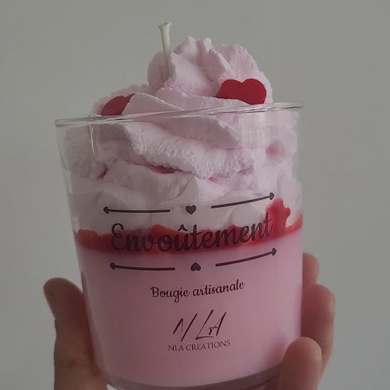 Vidéo montrant une bougie artisanale parfum Confiture de Lait, avec une cire couleur crème et une chantilly onctueuse en surface, décorée de détails gourmands, filmée en rotation lente pour mettre en valeur la douceur et la chaleur de la fragrance.