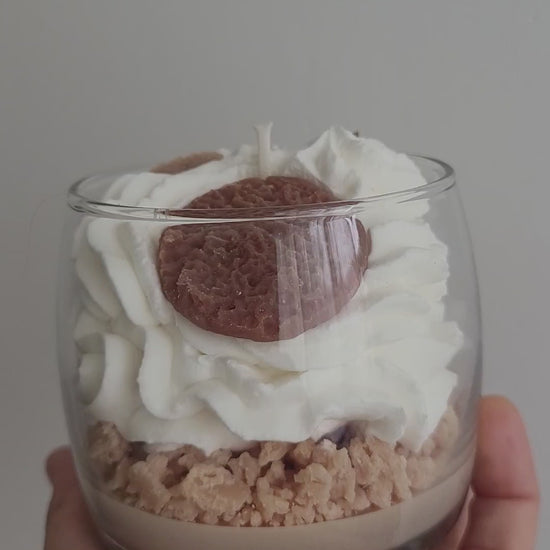  Gros plan vidéo d’une bougie artisanale parfum Éclats de Cookies, chantilly blanche avec crumble marron et petits cookies décoratifs, dévoilant les détails gourmands et la finition artisanale.
