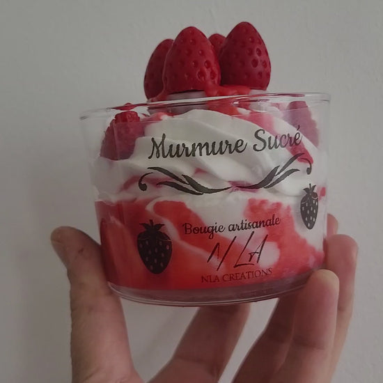 Gros plan vidéo d’une bougie artisanale parfum Murmure Sucré Fraise, chantilly blanche avec coulis rouge et petite tarte aux quatre fraises, montrant les détails gourmands et faits main.