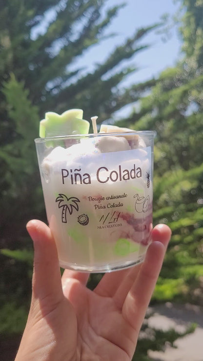 Bougie artisanale Pina Colada avec décoration en cire en forme de palmier, photographiée en extérieur sous le soleil