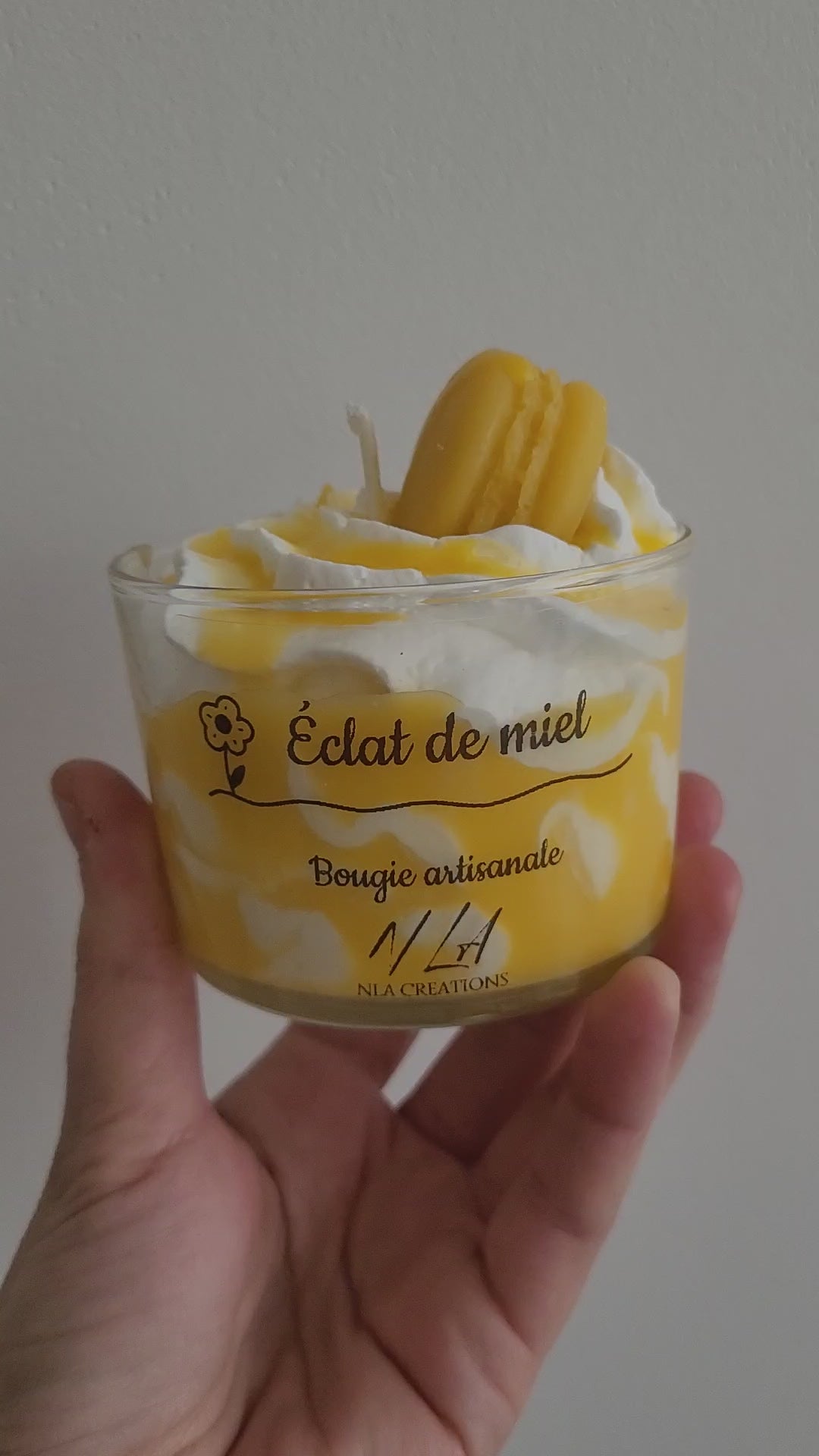 Vidéo d’une bougie artisanale couleur miel, décorée d’un macaron en cire sur une chantilly onctueuse. La caméra tourne autour du pot, mettant en valeur les détails et la texture crémeuse. Parfum doux et réconfortant de miel et avoine.

