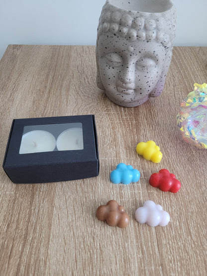 Cinq fondants parfumés artisanaux aux couleurs douces et textures originales, soigneusement disposés pour mettre en valeur leur aspect fait main.