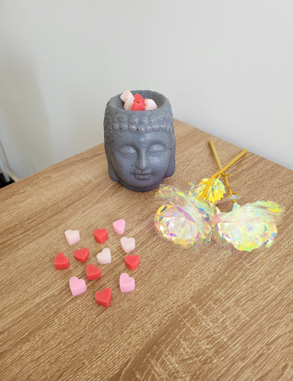 Brûleur parfum en céramique blanc élégant avec plusieurs petits fondants en forme de cœurs rose, rouge et blanc déposés dans la coupelle, prêt à diffuser le parfum frais et floral de Coquelicot Sauvage.