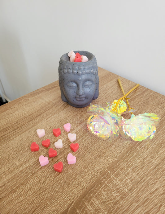 Brûleur parfum en céramique blanc élégant avec plusieurs petits fondants en forme de cœurs rose, rouge et blanc déposés dans la coupelle, prêt à diffuser le parfum frais et floral de Coquelicot Sauvage.