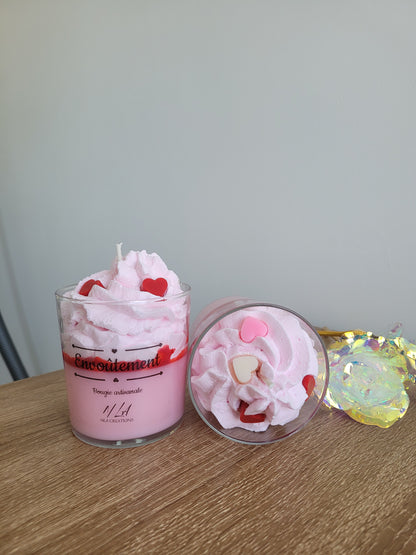 Photo d’une bougie artisanale parfum Confiture de Lait, avec une cire couleur crème et une chantilly onctueuse sur le dessus, décorée de petits éléments rappelant la douceur sucrée de la confiture de lait.
