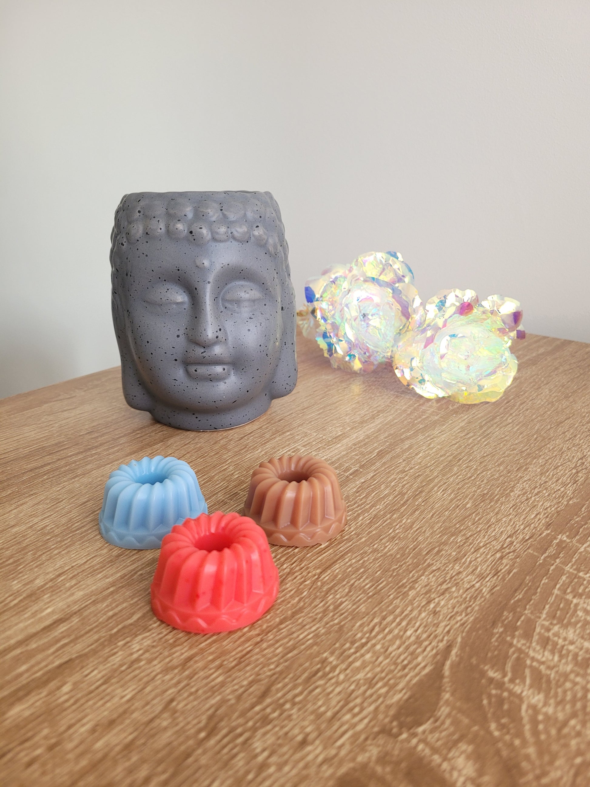 Collection de fondants forme savarin artisanaux, disponibles en plusieurs parfums fruités et floraux, diffusant des fragrances variées pour parfumer et embellir votre intérieur avec élégance.
