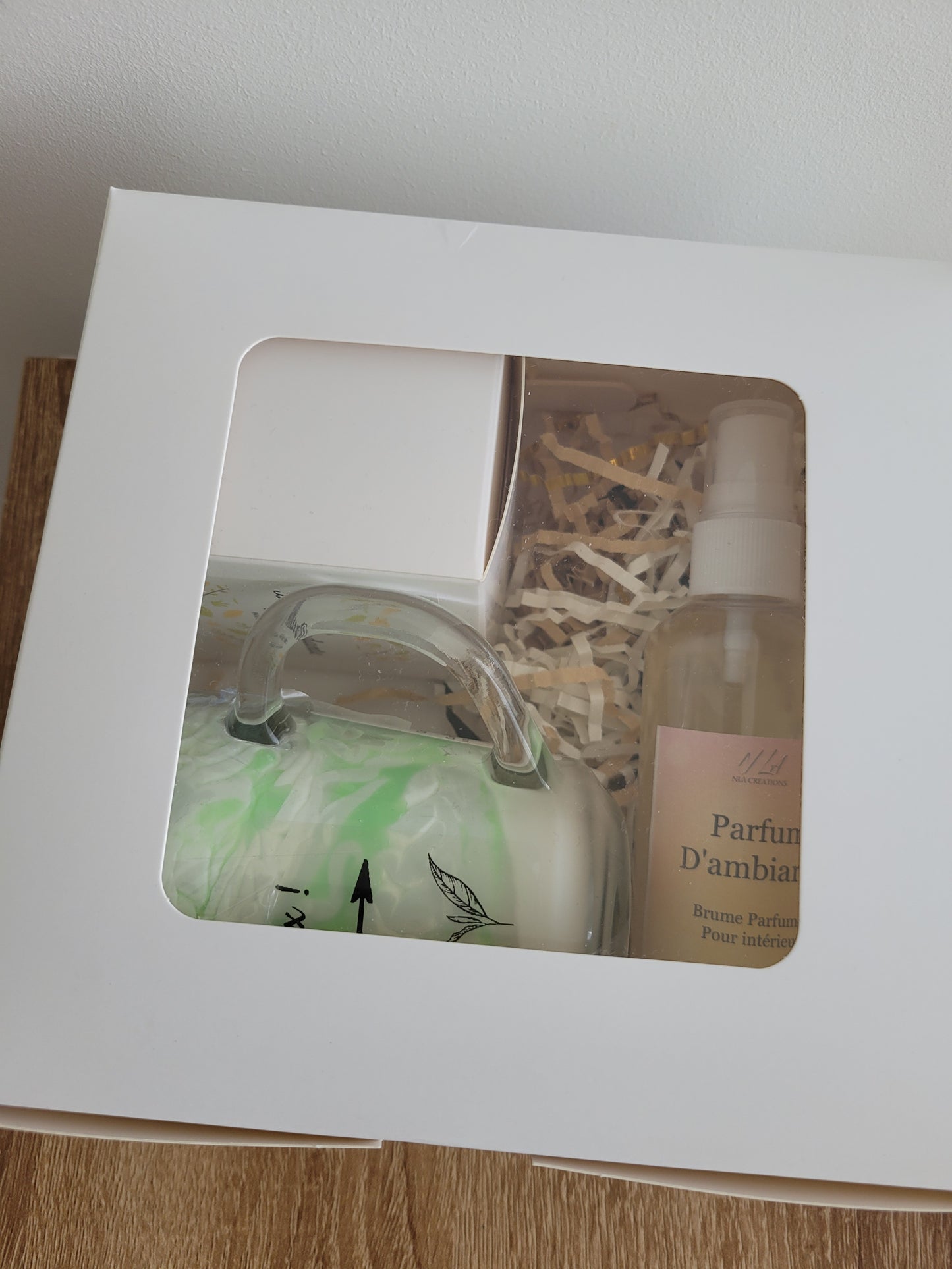 Coffret anti-moustique Citronnelle avec spray, fondant et bougie, entouré de feuilles de citronnelle fraîches.