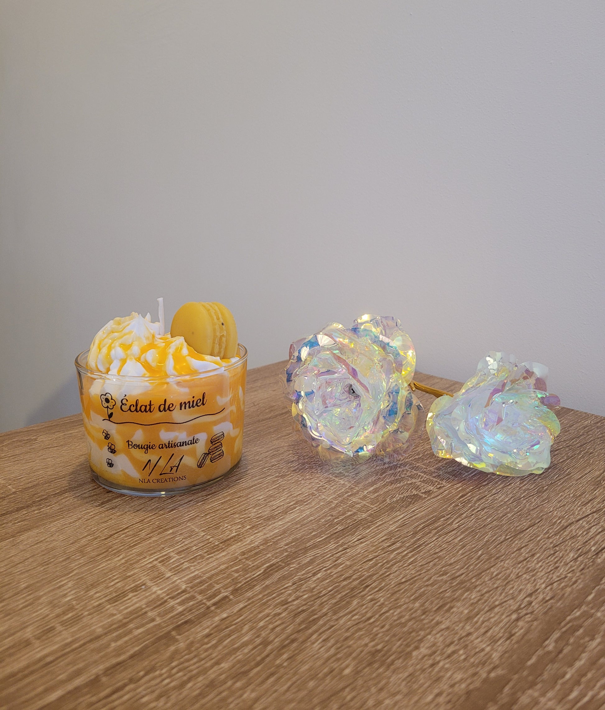 Bougie artisanale couleur miel, présentée dans son contenant en verre, avec un macaron décoratif posé sur la chantilly. Parfum Miel Avoine, ambiance douce et réconfortante.